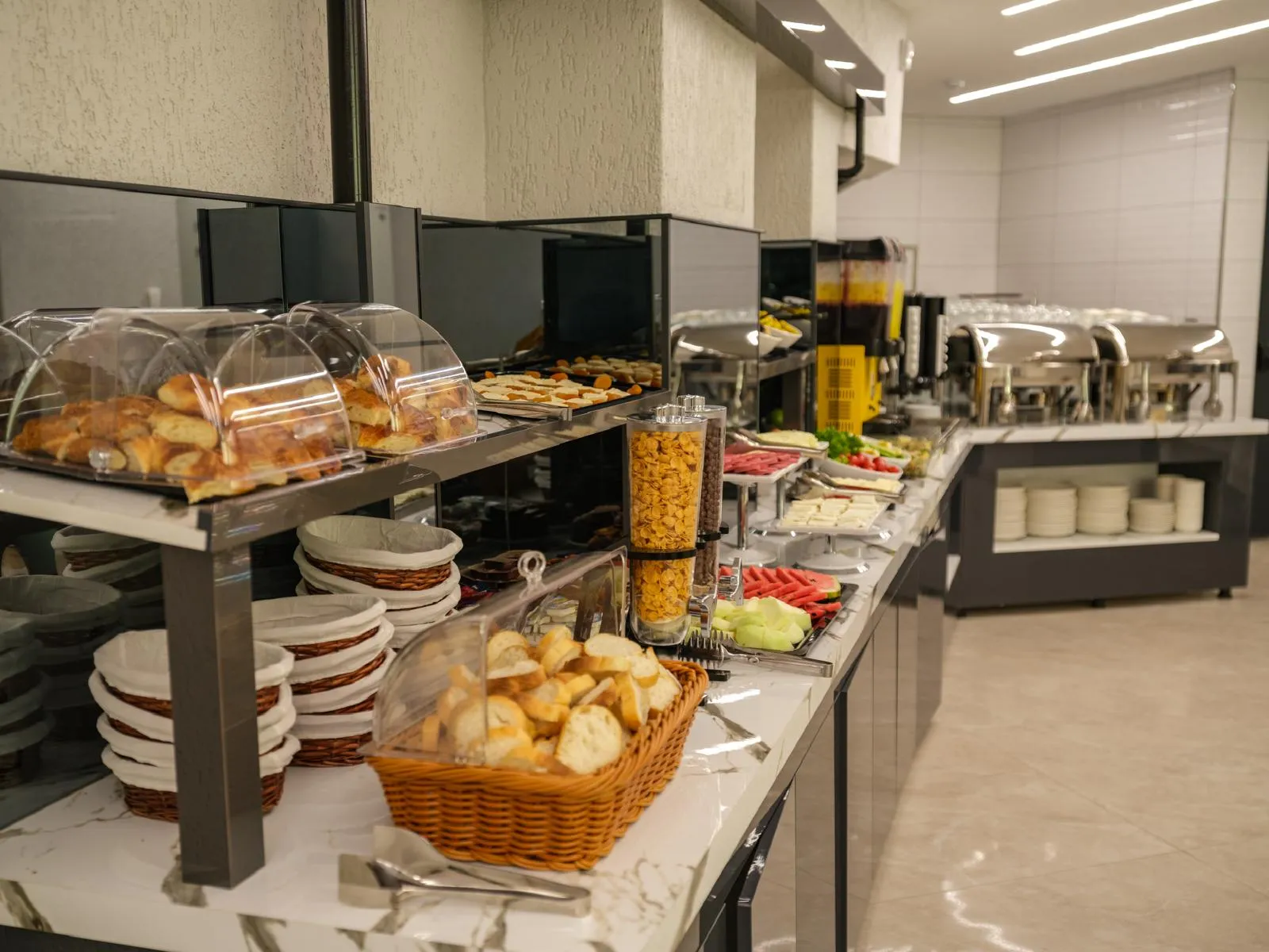 Kahvaltı büfesinde ekmek ve poğaça sepetleri ile çay kahve ünitesi